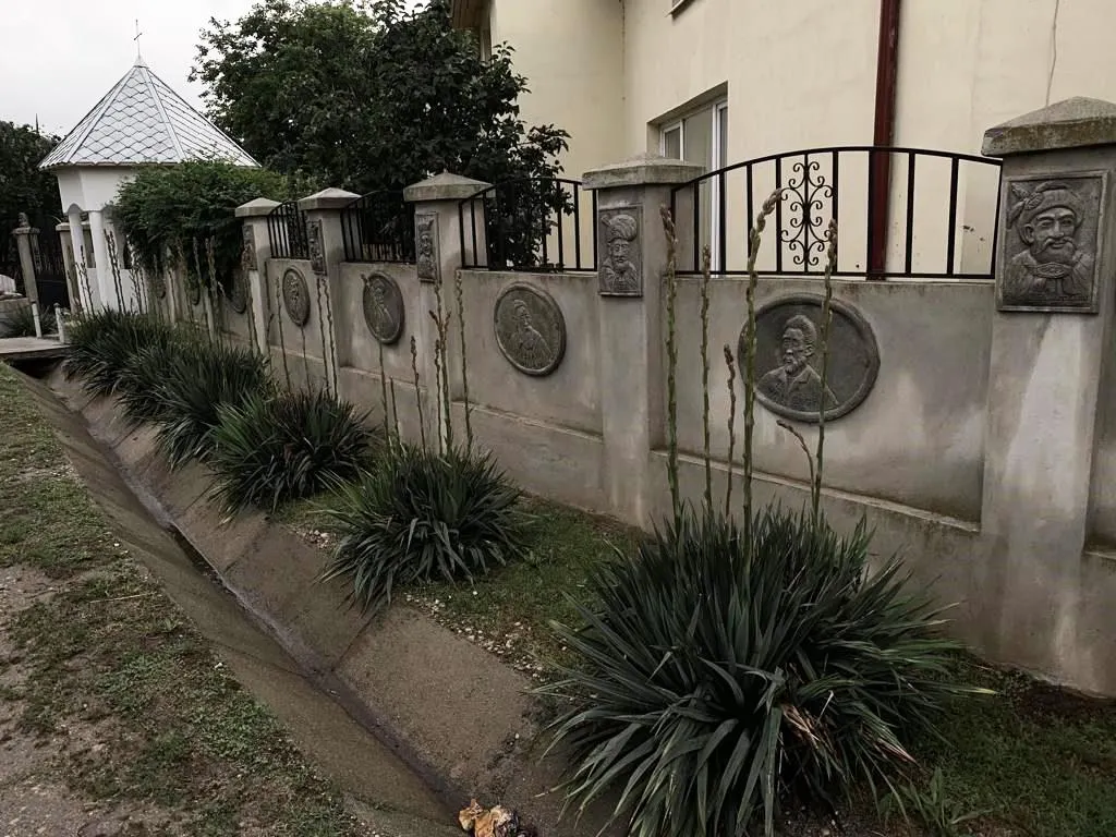 FOTO Un argeșean stabilit în Vișina și-a decorat gardul cu chipuri de domnitori și mari artiști