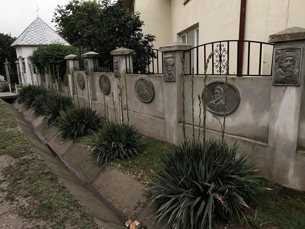 FOTO Un argeșean stabilit în Vișina și-a decorat gardul cu chipuri de domnitori și mari artiști