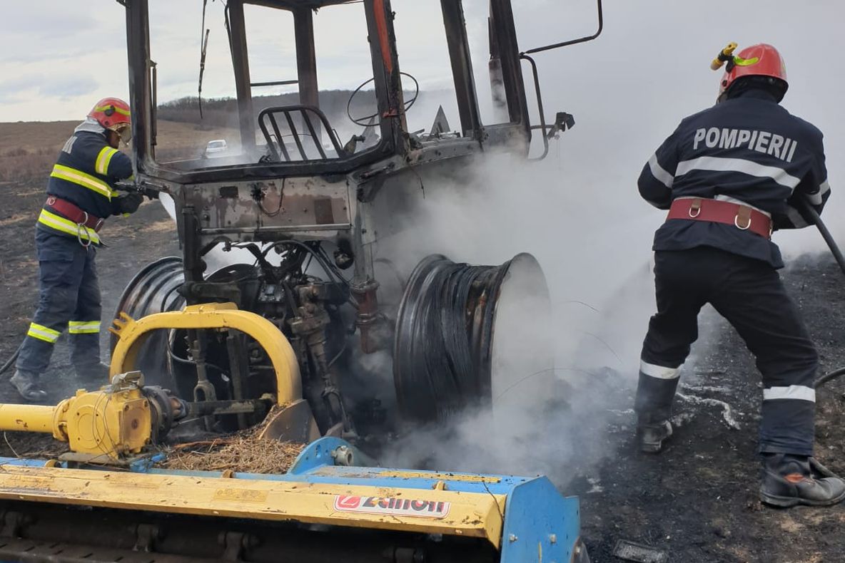 Foto | Utilaj agricol prins în mijlocul unui incendiu de vegetație. Șoferul mașinii intoxicat cu fum