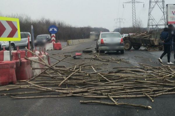 Lemne împrăștiate pe șosea, după ciocnirea dintre o mașină și o căruță